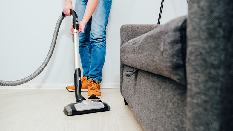 man vacuuming near couch