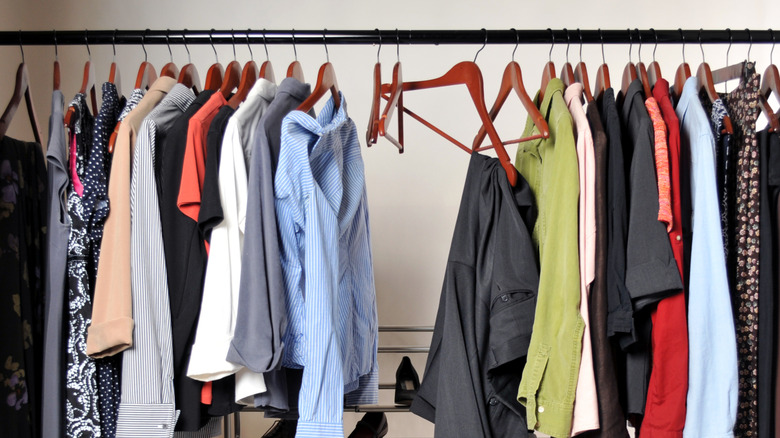 Messy closet with clothes hanging from a rod