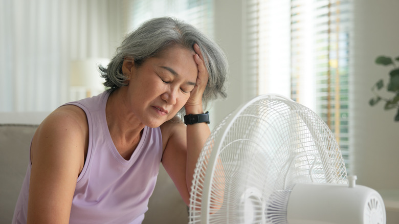 person using fan indoors to stay cool