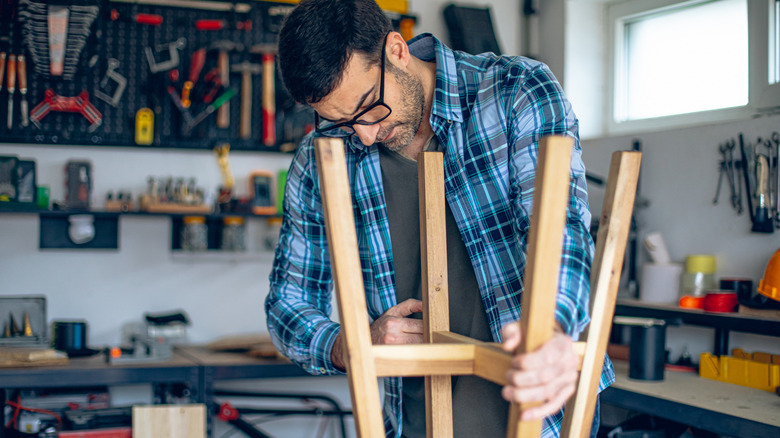 Man assembles a stool in his garage