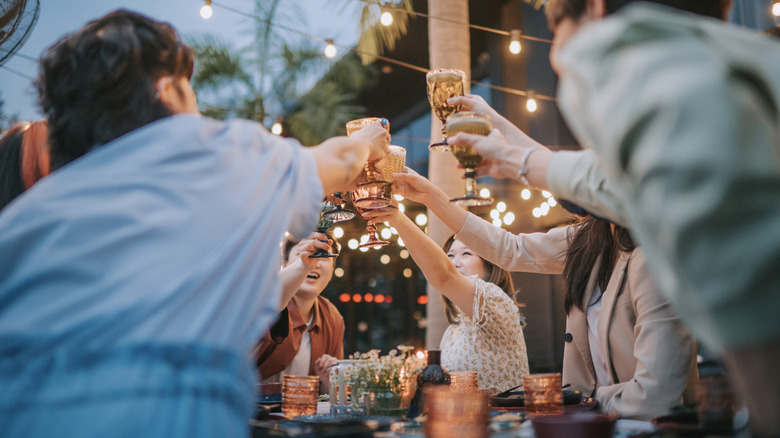 People doing cheers on outside patio.