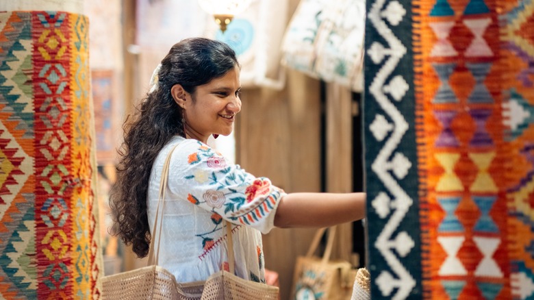 Person shopping for colorful rugs