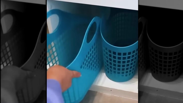 Placing blue storage baskets into cube shelf