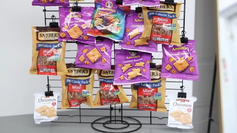 Snacks hang on a home-made rack made from Dollar Tree items.