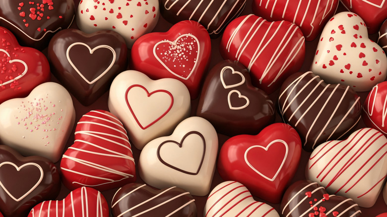 Heart-shaped Valentine's Day chocolates in brown, white, and red.