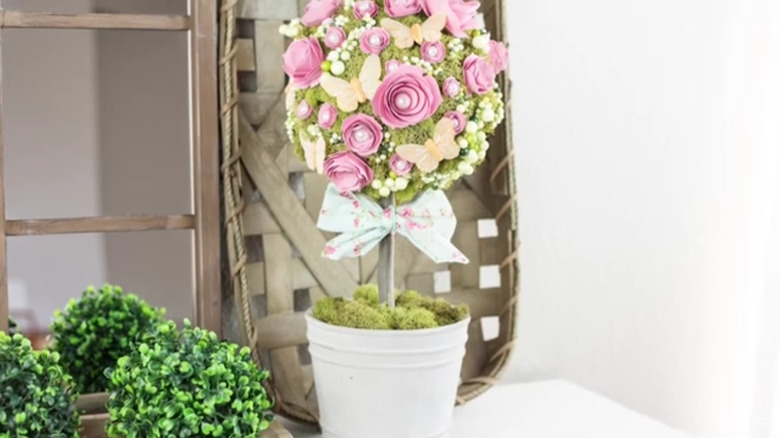 A floral topiary featuring several kinds of flowers and greenery