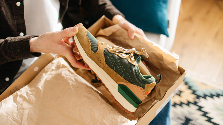 Man opening a box containing new shoes