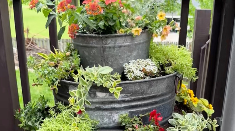 Three tiers of the finished planter are shown with flowers.