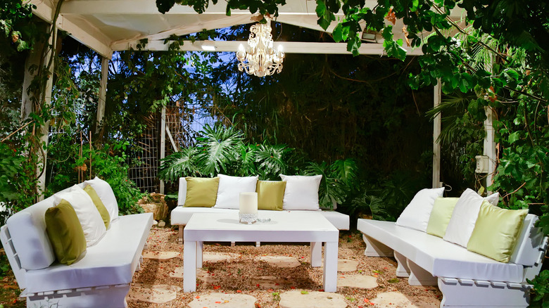 an elegant patio with couches and a chandelier 