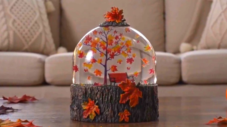 Maple leaf autumn snow globe on table