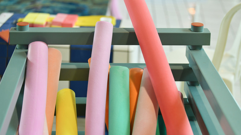 Colorful pool noodles in a bin at the store.