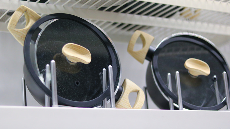 Pot lids organized on a metal rack