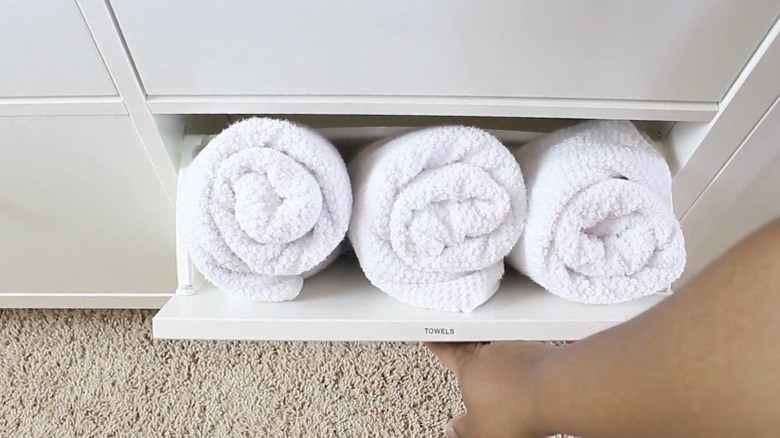 A shoe cabinet doubling as a bathroom towel storage solution