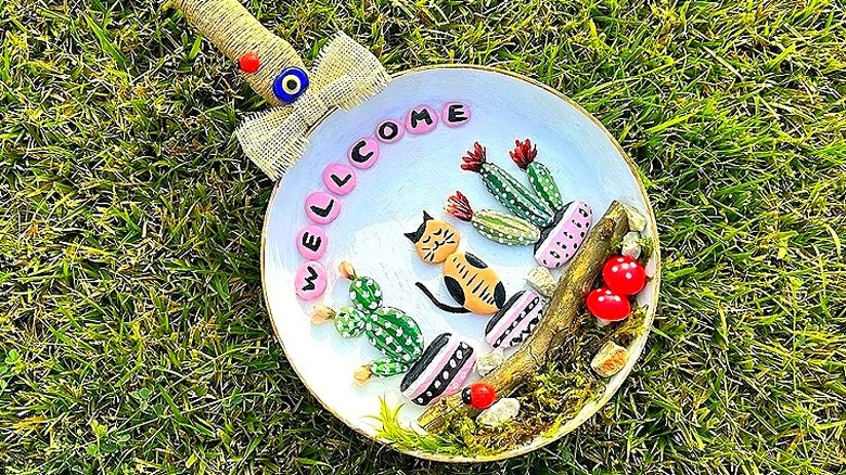 An upcycled frying pan turned into décor sits atop grass