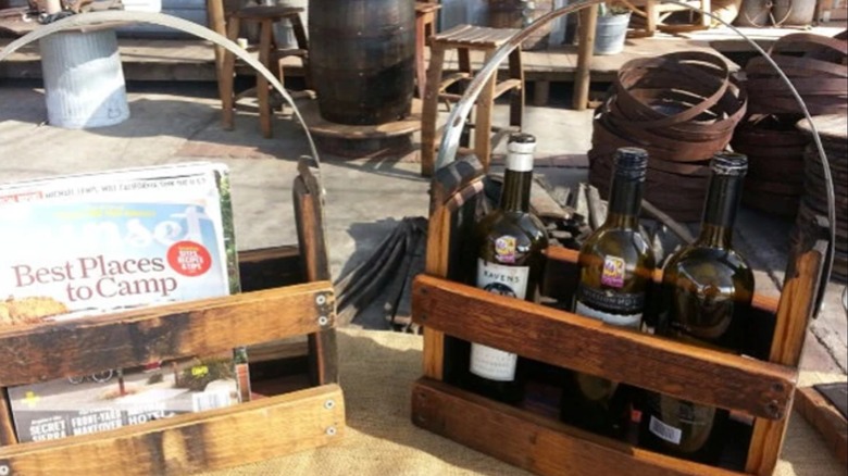 Wood and metal magazine racks, one holding wine bottles