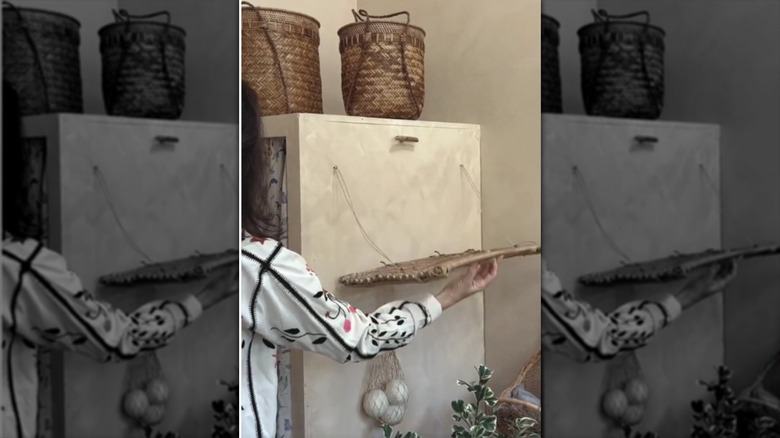 A laundry rack made from a vintage French baking rack being held by a person