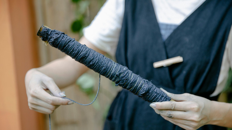 A person's hands unraveling some cord