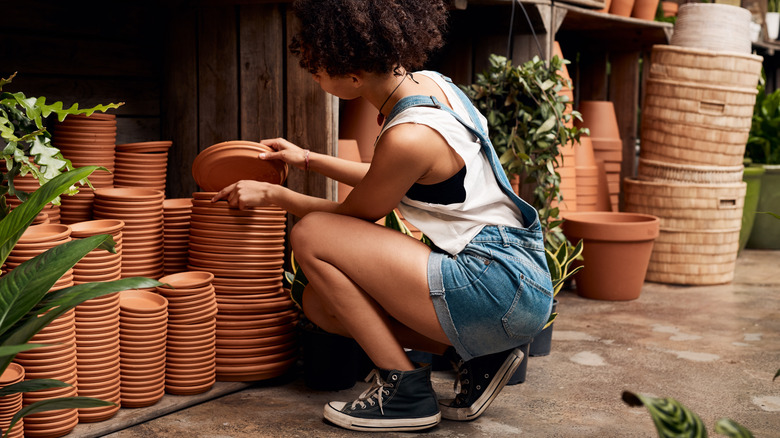 person looking through planter saucers