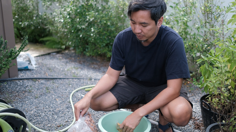 A person making a water fountain in their backyard using affordable materials.