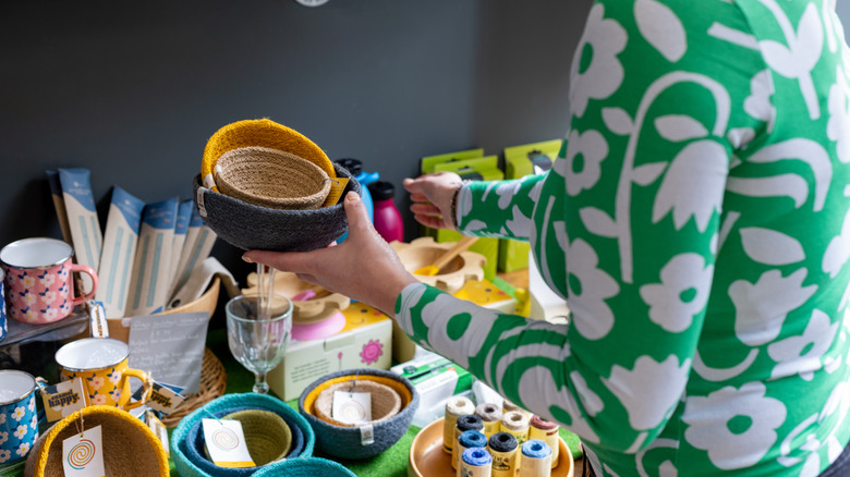 Woman picking up baskets and supplies at store