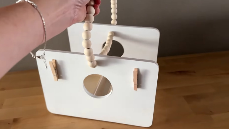 Hand holding empty wooden storage basket made with Dollar Tree supplies