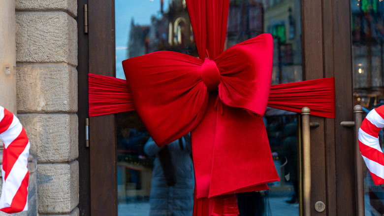 A bright red holiday bow tied on a door