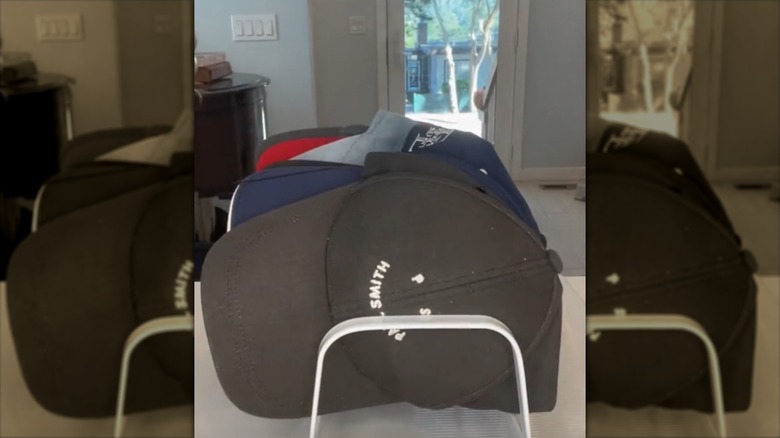 Baseball caps stored on a dish drying rack