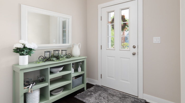 An entryway table with storage shelves by the front door