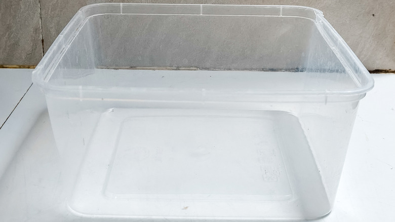 A clear, empty plastic ice cream container.
