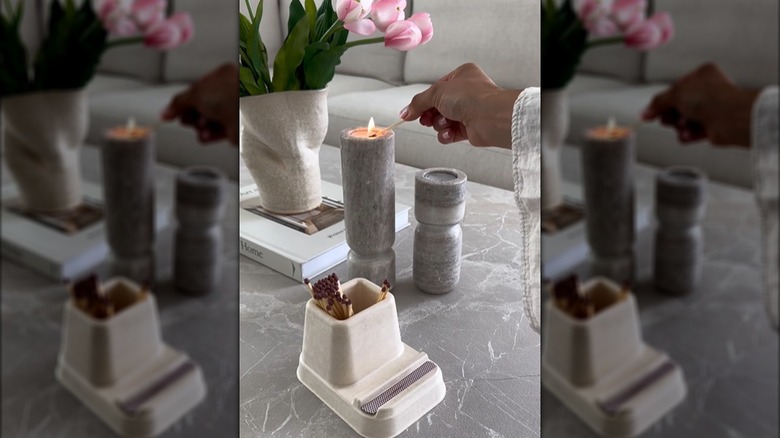 A hand lights a candle with a match stored and struck on an IKEA desk organizer.