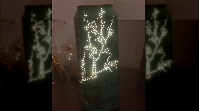 An Arizona green tea can with a punched hole design is glows with LED light.