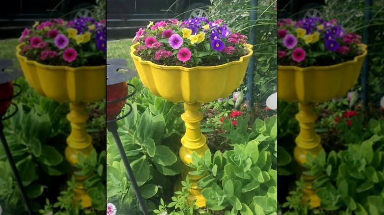 Bundt pan and lamp based painted yellow and turned into a pedestal planter in the garden.