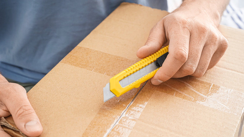Man cutting open a box