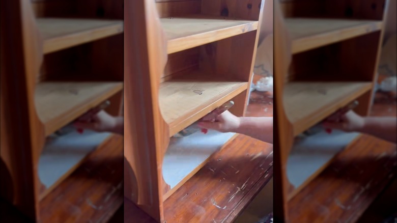 Person painting a repurposed CD rack