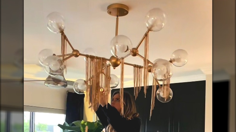 Hanging metal chains from chandelier