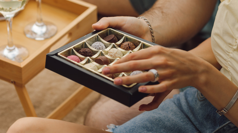 Couple sitting together holding a box of chocolates