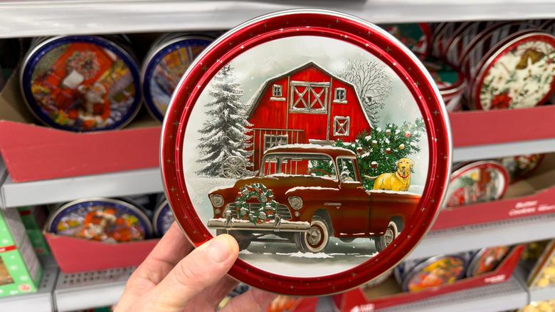 A person holding a Christmas cookie tin in the store