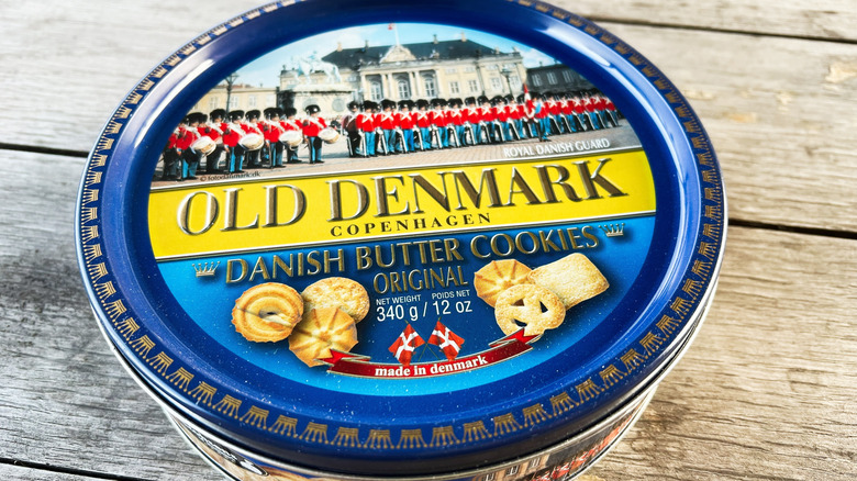 A vintage cookie tin sits on a wooden table.