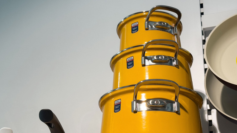 Stacked cooking pots on a shelf in a kitchen