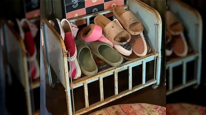 Shoes in middle section of blue vintage doll bed frame.