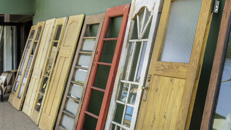 Salvaged wooden doors leaning against a wall.