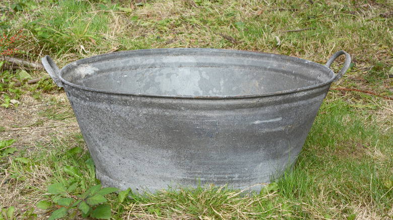 Old galvanized tub sitting on grass