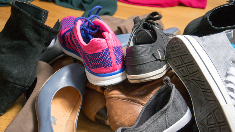 Pile of shoes on wooden floor.