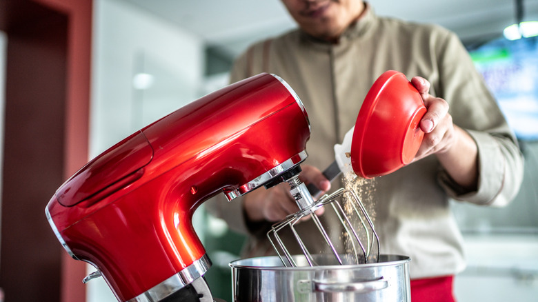 Chef pouring ingredients into a mixing bowl