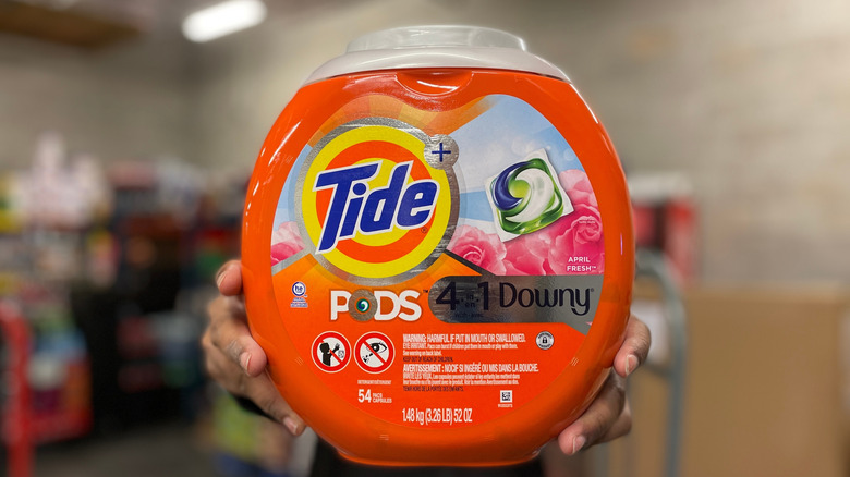 someone holding up a laundry pod container