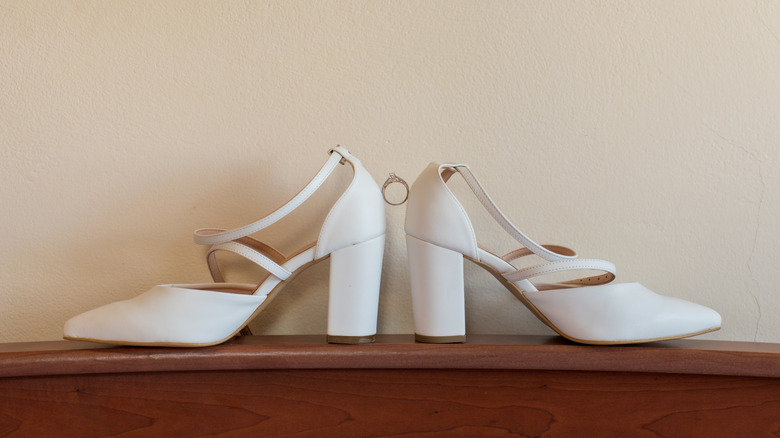 Close up of pair of white chunky heeled shoes