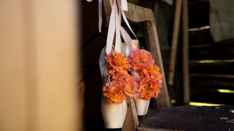 Pointe shoes hanging on a barre