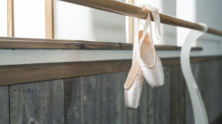 Ballet pointe shoes hanging on a barre