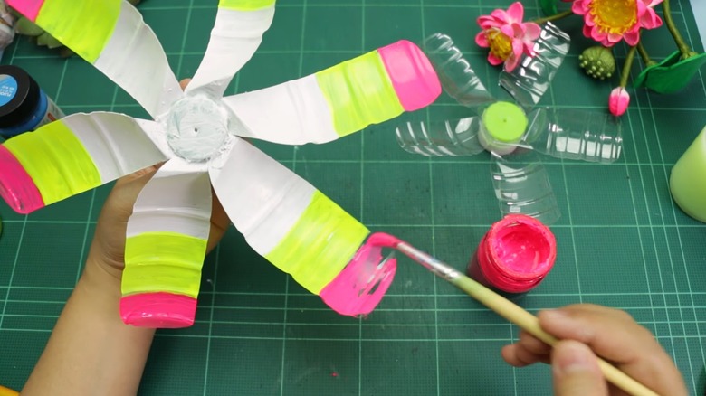 Hands painting the blades of a wind spinner