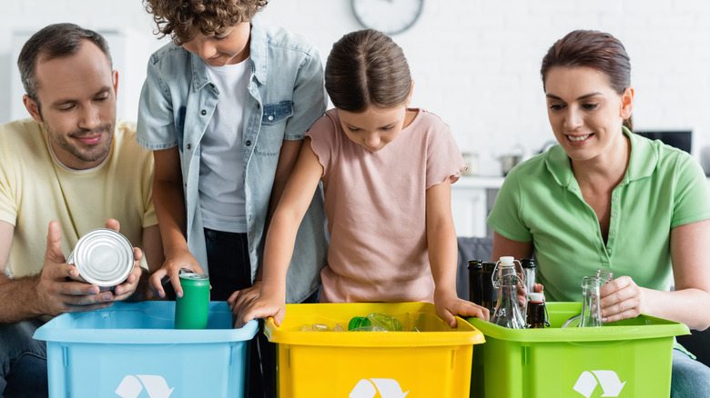 Family sorting through recycling bins